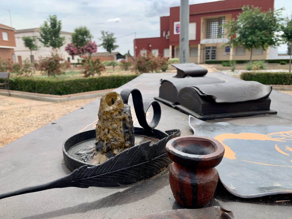 mesa con pluma, tintero, libros y candil, todo en hierro farjado